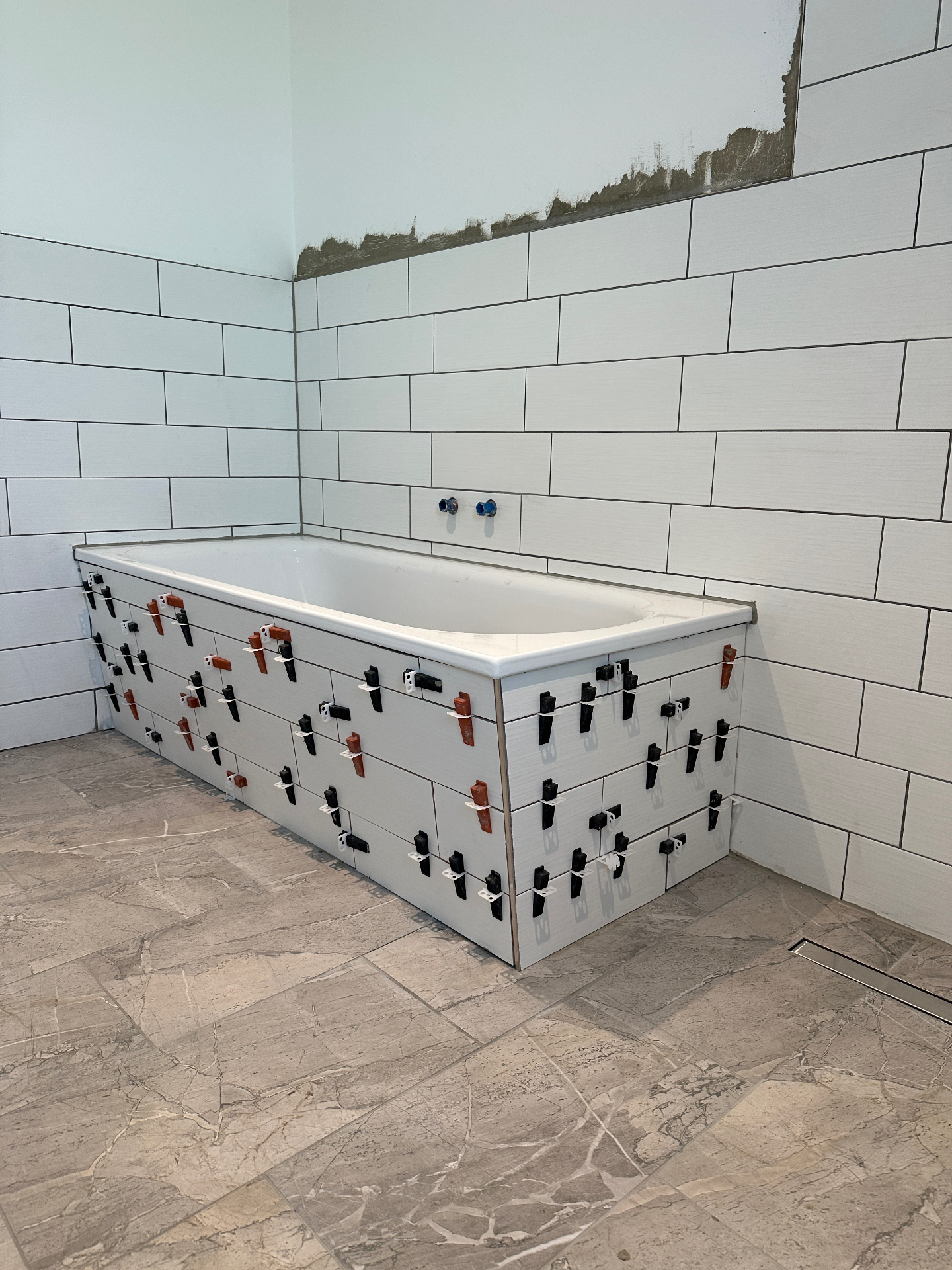 Fliesenverlegung an der Badewanne mit Nivellierkeilen